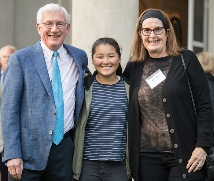 three people posing and smiling for the camera at an event